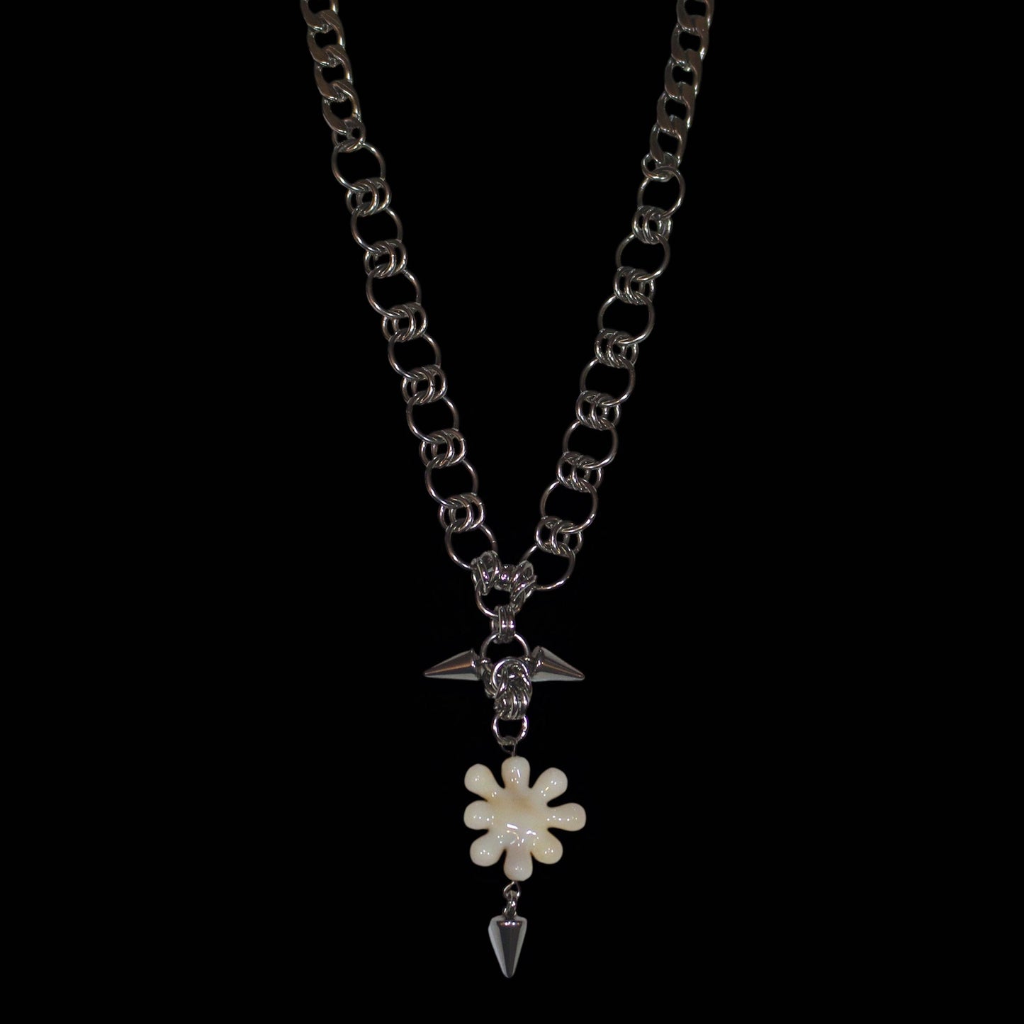 Necklace with a irregular flower like pendant and spike on a white background