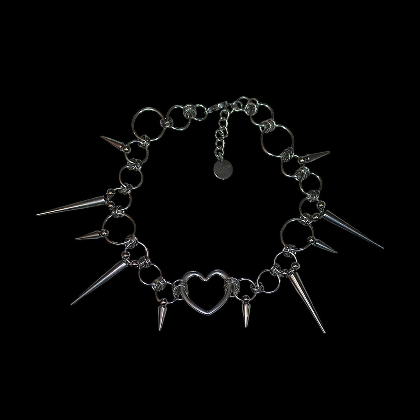 Neckace with spikes and heart charm on a black background