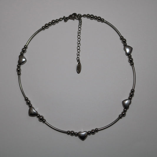 Stainless steel tube bead necklace with heart-shaped beads on a white background
