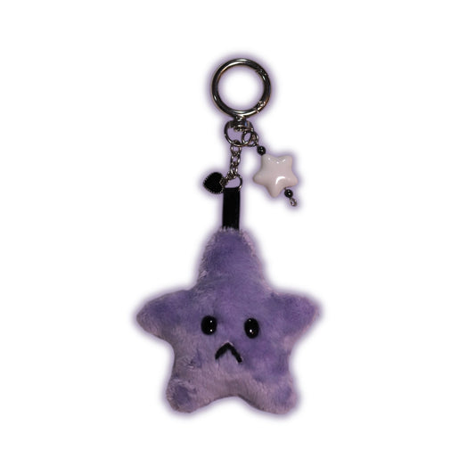 Purple star-shaped keychain with a sad face on a white background