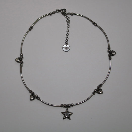 Silver necklace with star pendant and additional heart charms on a white background