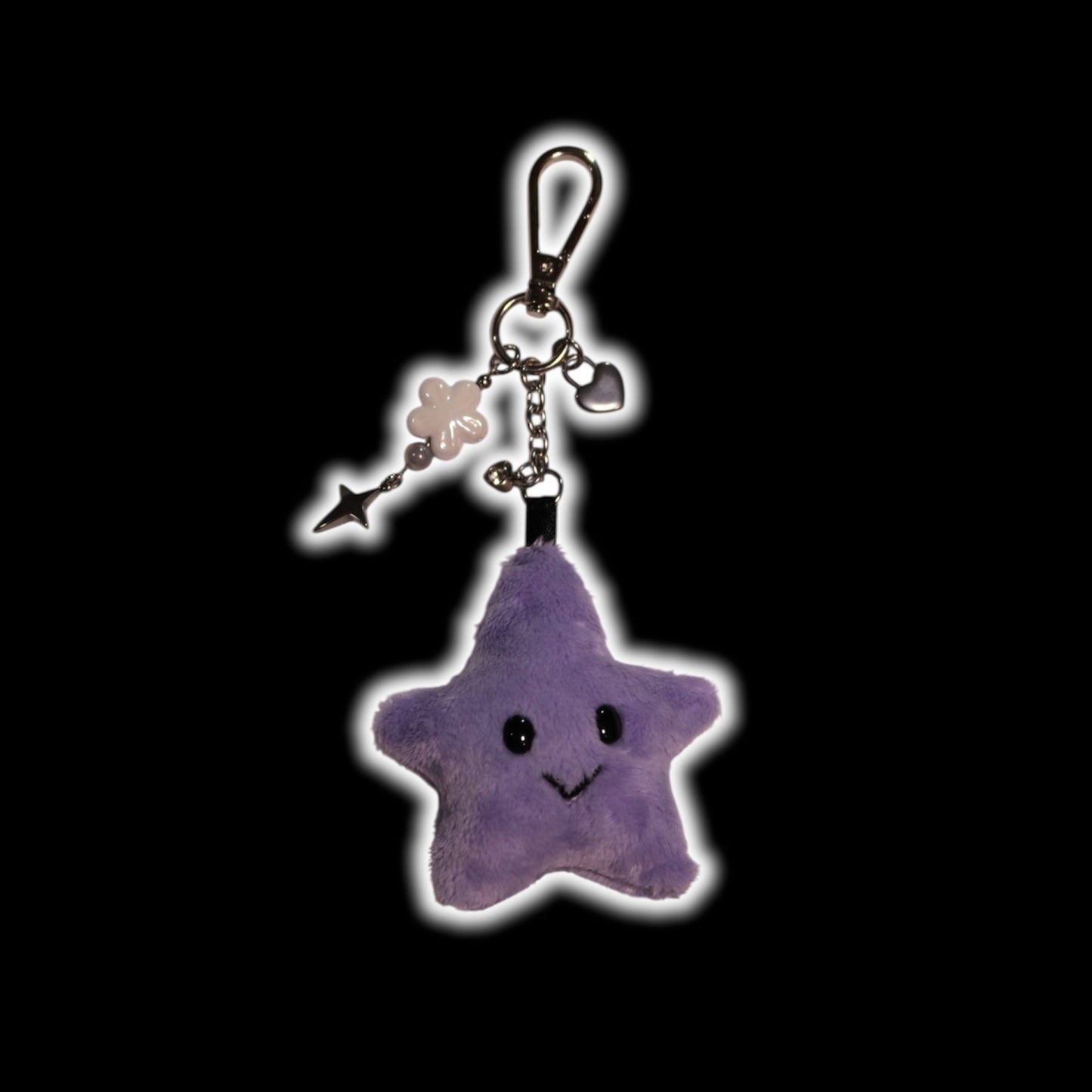 Purple star-shaped keychain with a smiling face on a black background