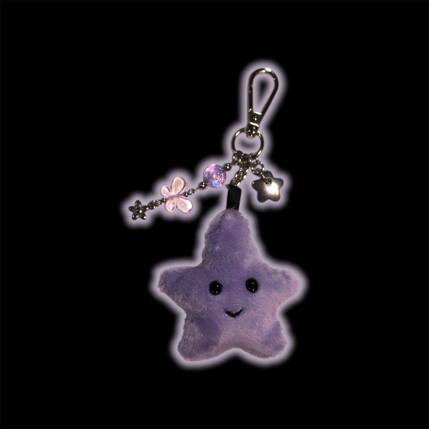 Purple star-shaped keychain with decorative elements on a black background