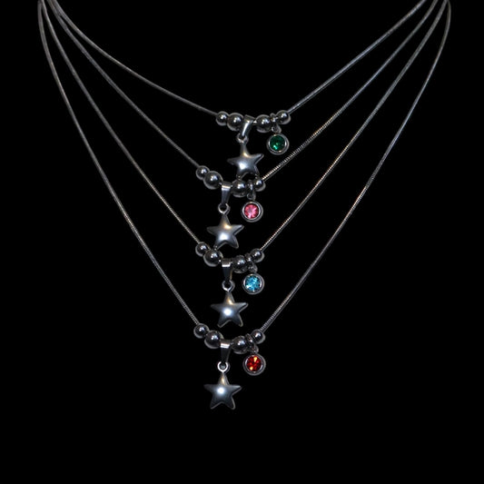 Necklaces with star-shaped pendants and colored gems on a black background