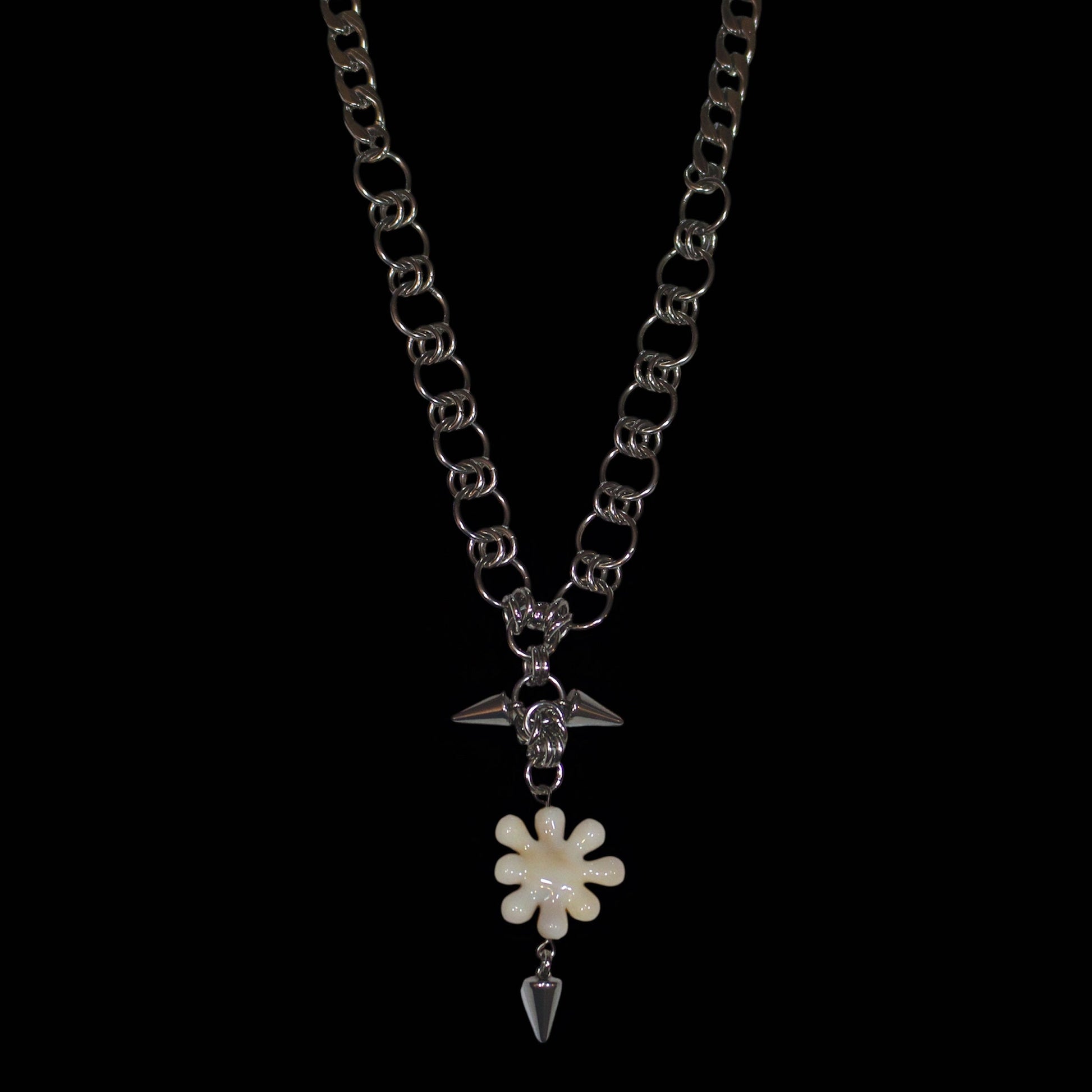 Necklace with a irregular flower like pendant and spike on a white background