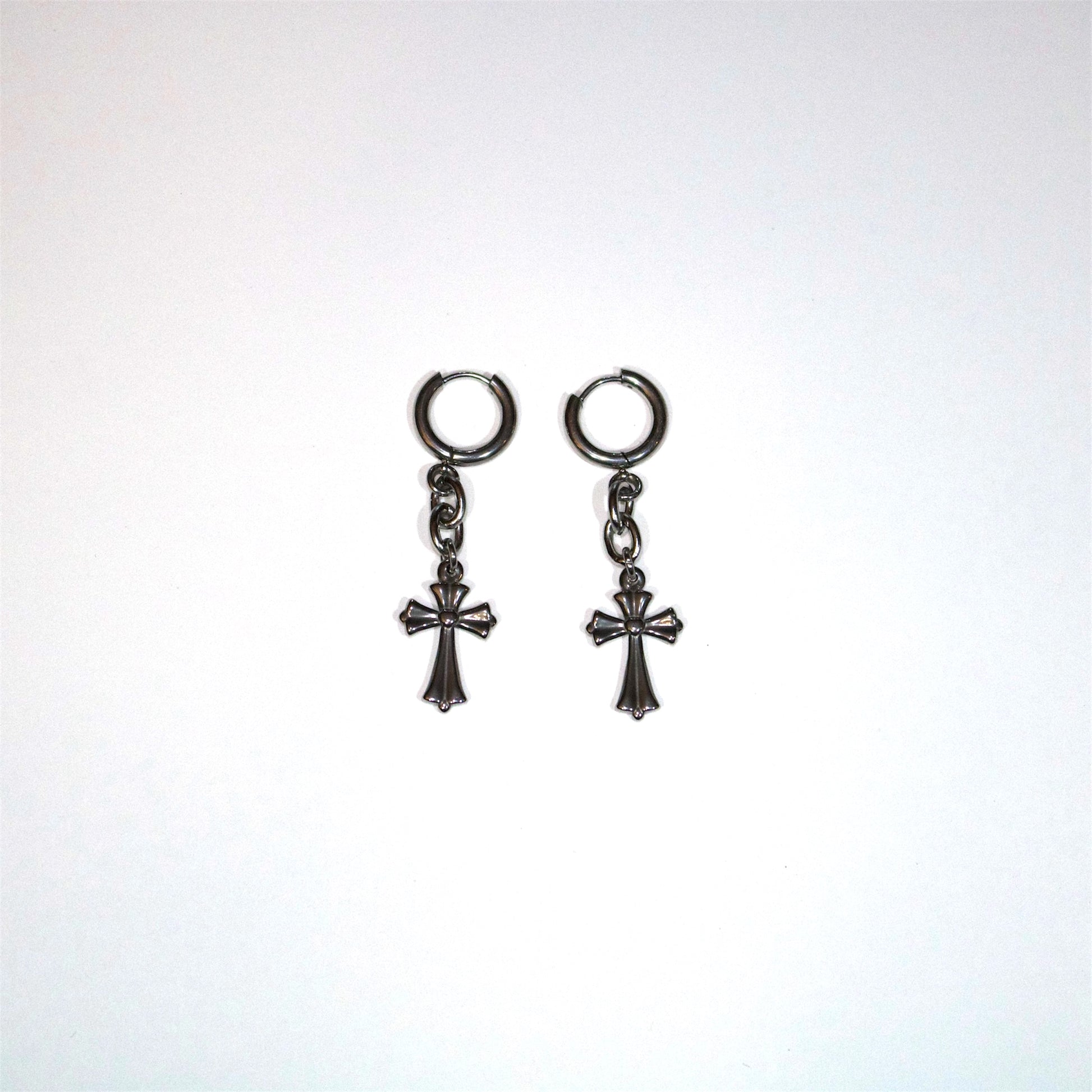 Pair of stainless steel cross drop earrings on a white background