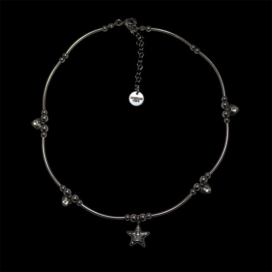 Stainless steel necklace with center star charm and additional heart charms on a black background