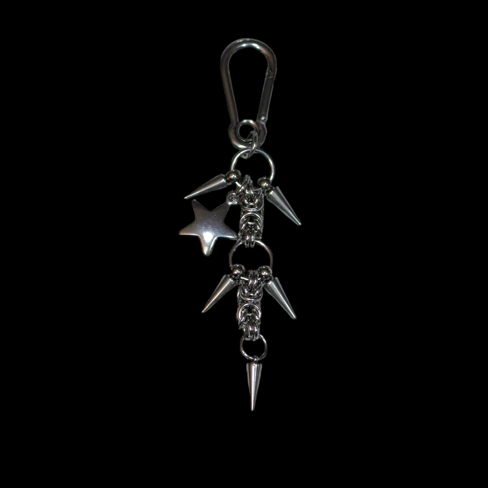 stainless steel keychain with spikes and a star charm on a black background