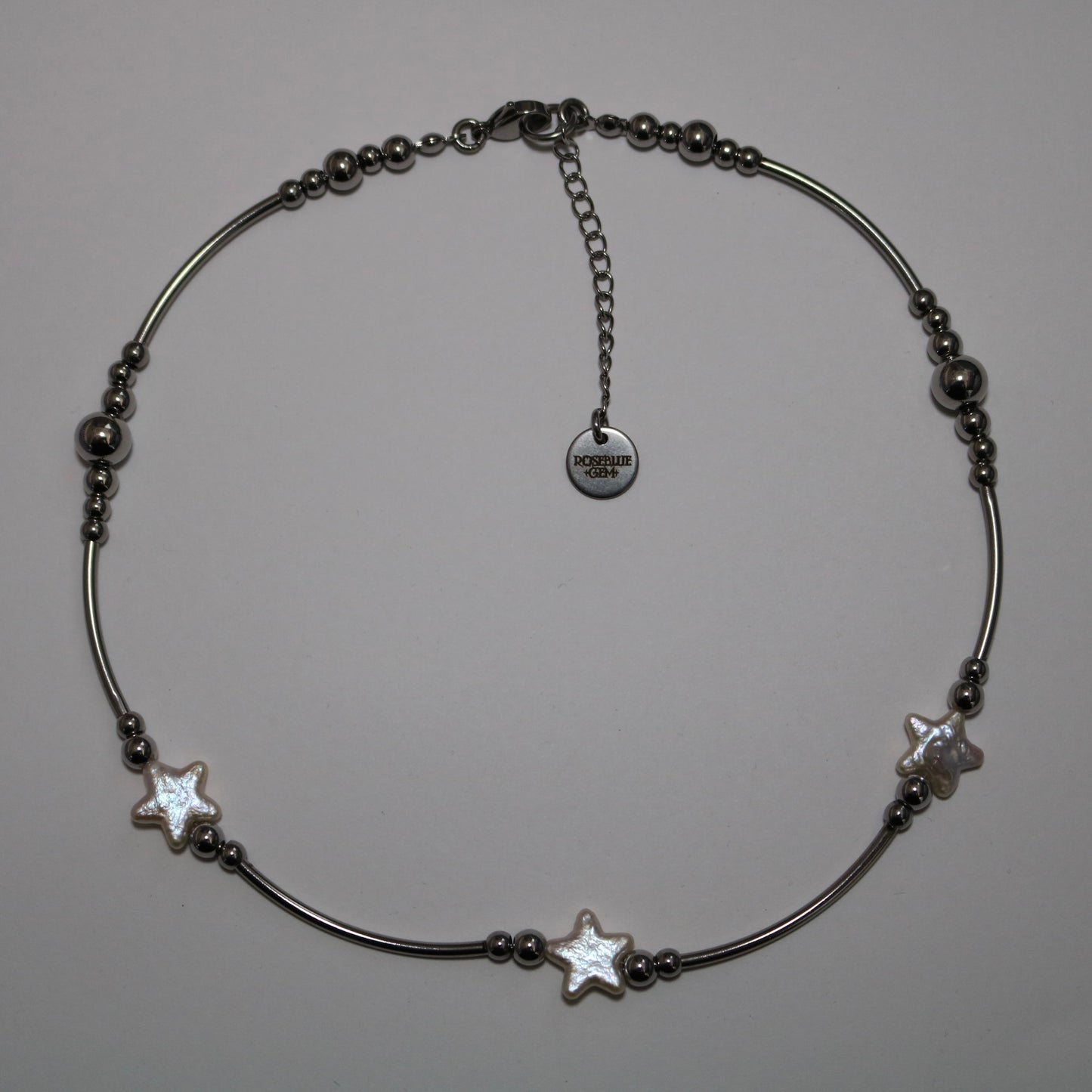 Necklace with stainless steel tube beads and star shape pearls on a white background
