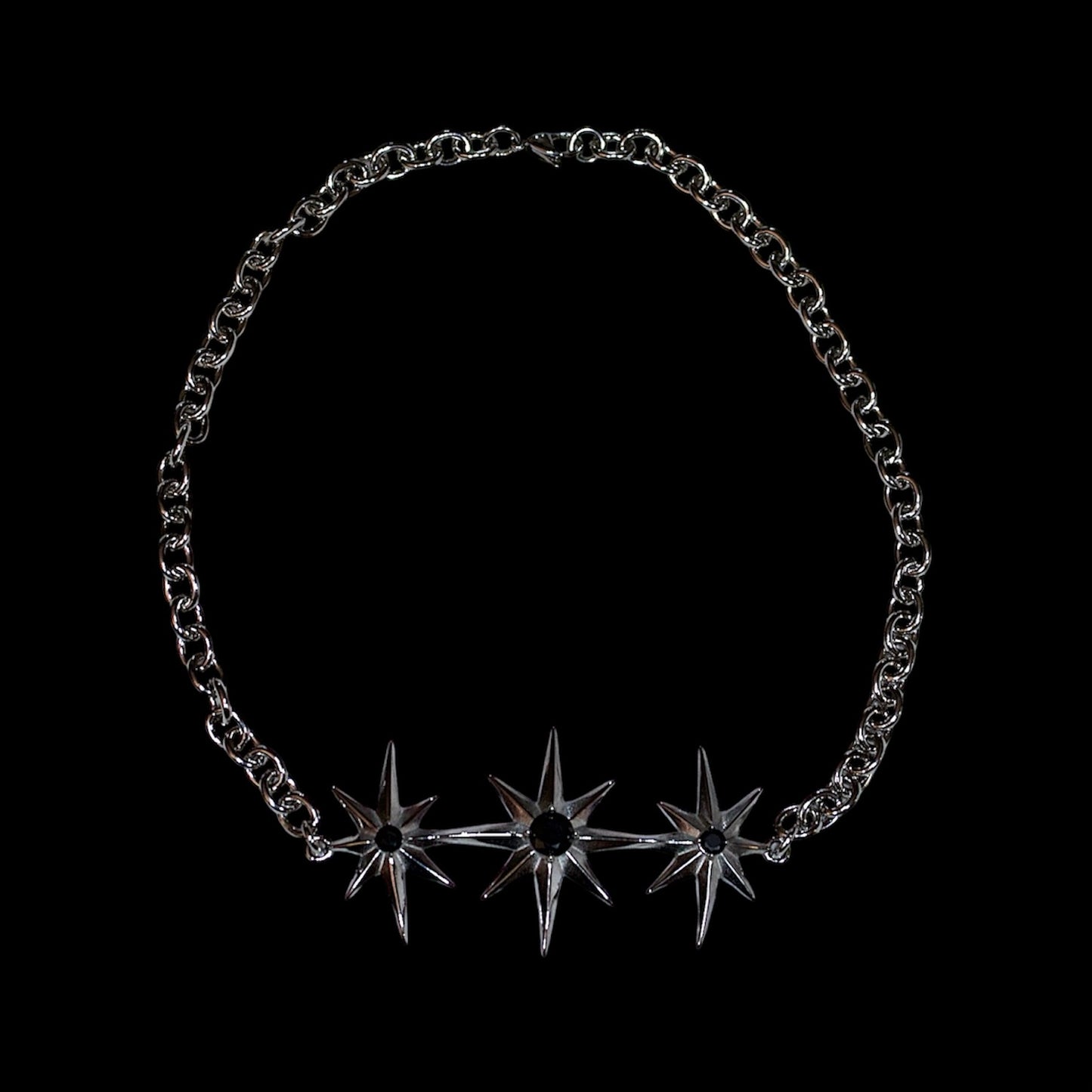 stainless steel chain necklace with north star-shaped pendant on a black background