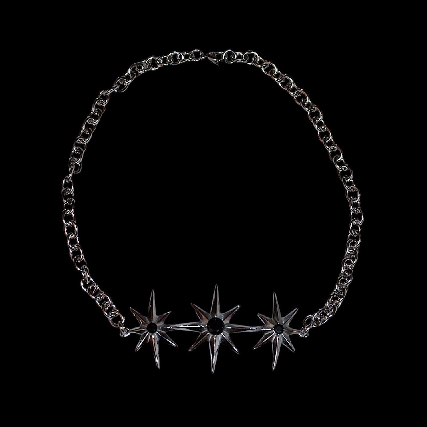 stainless steel chain necklace with north star-shaped pendant on a black background