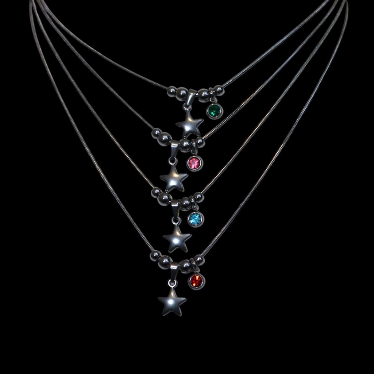 Necklaces with star-shaped pendants and colored gems on a black background