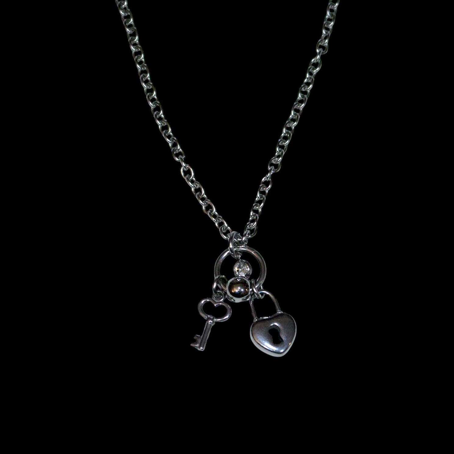 Necklace with key and heart lock pendant on a black background